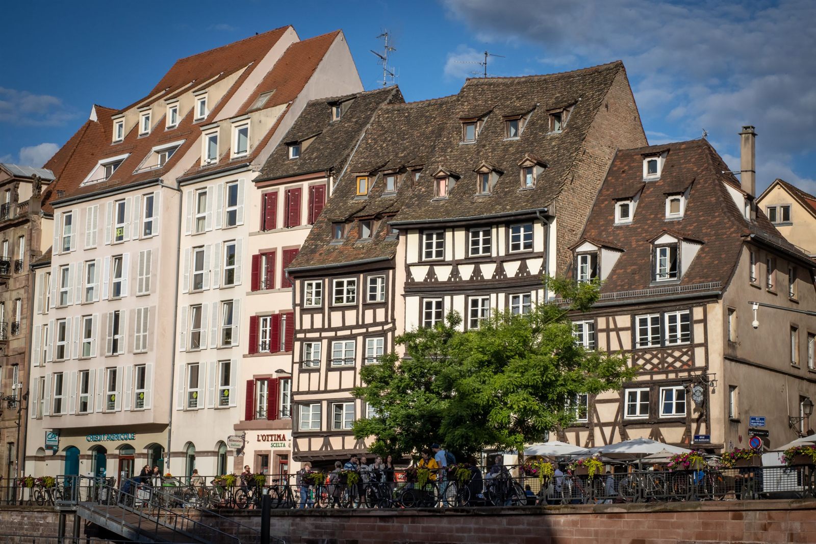 Half-timbered houses and cafe tables along the riverfront in Strasbourg, France